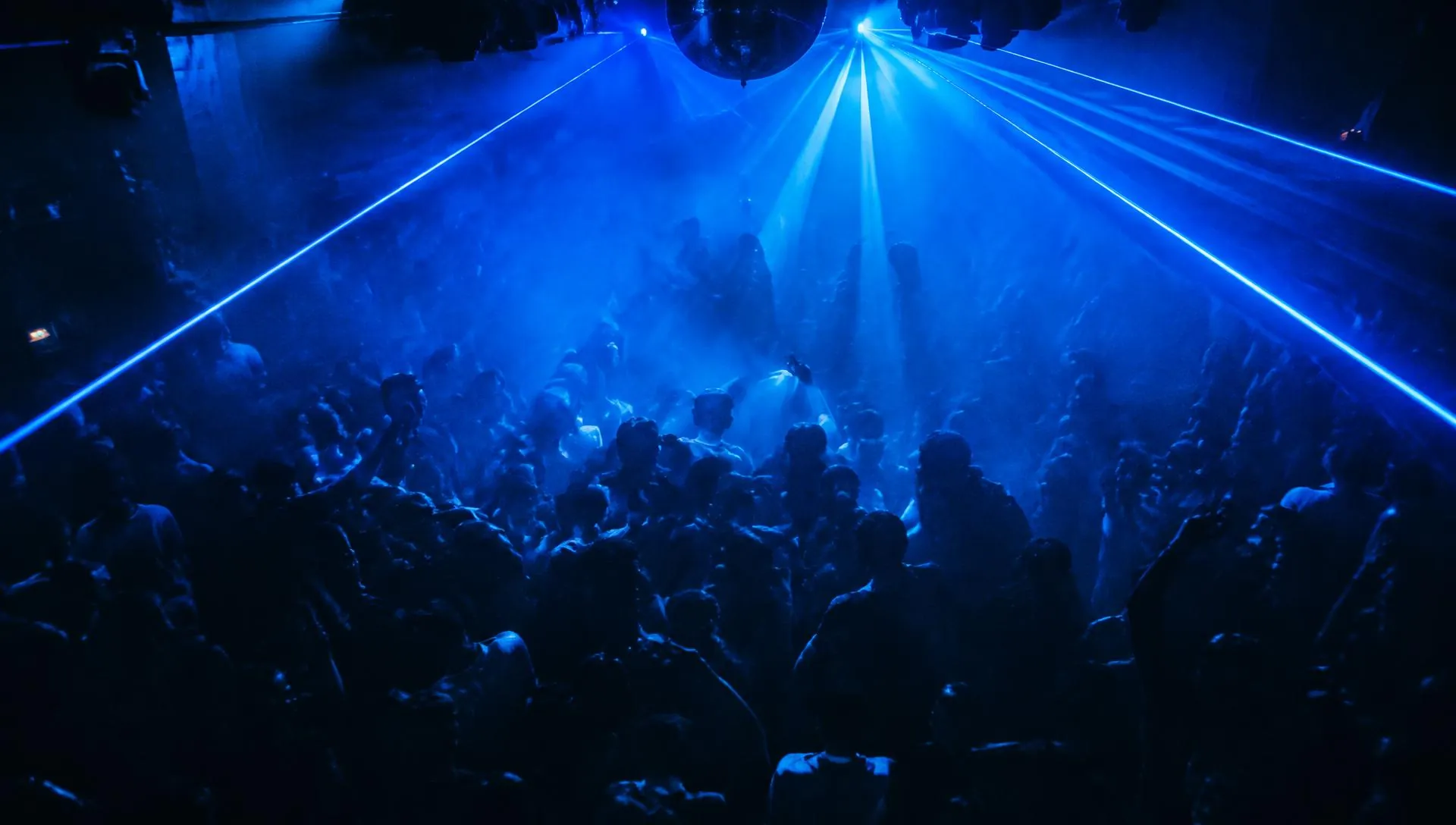 Pista lotada sob lasers azuis em uma noite premium
