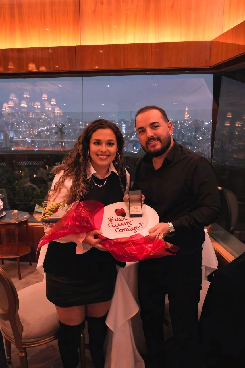 Casal com o prato "Quer casar comigo?" e buquê no Terraço Itália